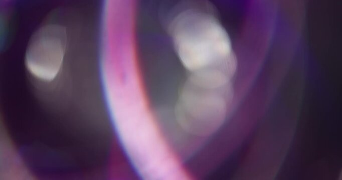Defocused disco color. Sparkle flash. Neon light lens flare gleam optical circles twirling on blurred with bokeh background.