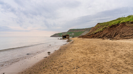 A destroyed World War II bunker on the beach of Cayton Bay, England, UK