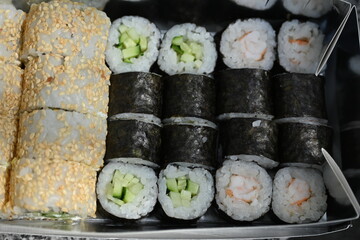 Sushi Rolls in Takeout Box, Street Food Sushi in Paper Box – Close View, Takeaway Sushi Rolls – Close-Up Shot, Japanese Street Food – Sushi Rolls in Cardboard Box, Fresh Sushi Takeout – Macro