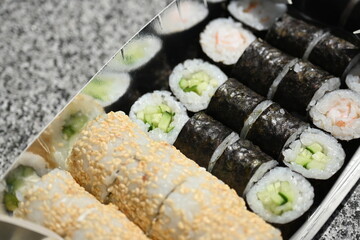 Sushi Rolls in Takeout Box, Street Food Sushi in Paper Box – Close View, Takeaway Sushi Rolls – Close-Up Shot, Japanese Street Food – Sushi Rolls in Cardboard Box, Fresh Sushi Takeout – Macro