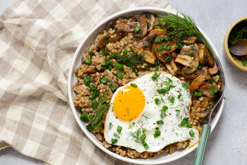 Bowl with buckwheat, fried mushrooms and fried egg for breakfast. vegeterian dish