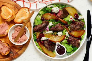 Fresh green salad with chicken liver, caramelized pear, raspberries and cheese.top veiw