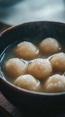 Delicate rice balls in a syrupy soup capture a classic New Year dessert flavor. Vertical.