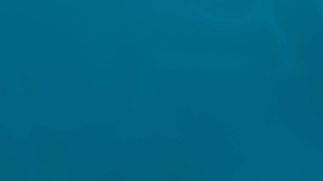 Seamless loop background in solid teal color with smooth texture, 4K.