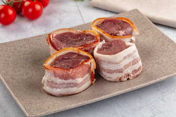 Raw pork tenferloin with bacon