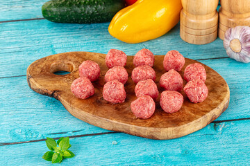 Raw beef meatballs over board