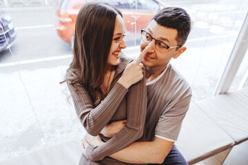 Couple sharing a playful moment in a cozy cafe during the afternoon