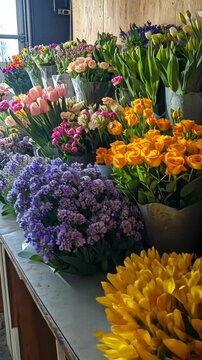 Fresh blooms are organized into elegant bouquets in celebration of Mother's Day. Vertical.