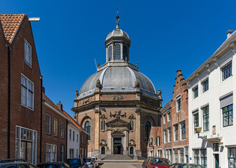 View through a historic brick street to the entrance of the East Church (Oostkerk) in Middelburg, province of Zeeland, The Netherlands