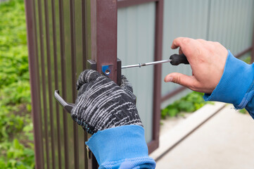 Installing a door lock. The worker selects a bolt for the door lock.