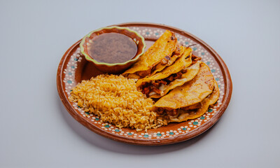 Authentic Mexican Quesabirria tacos with melted cheese and shredded beef, served on a traditional clay plate. Rustic street food isolated on a clean white background.