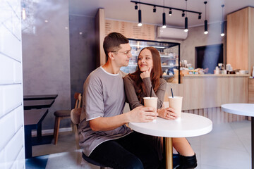 Couple enjoys beverages at a modern cafe in the afternoon while sharing smiles and conversation together