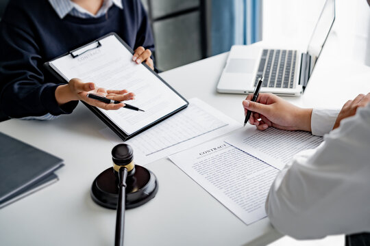 serious courtroom lawyer preparing litigation documents for business client before official hearing