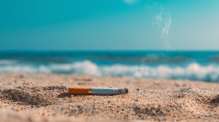 Burnt cigarette butt lying on sand