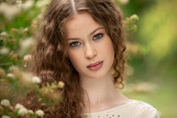 Fototapeta premium Portrait of beautiful young girl in park in spring