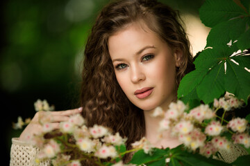Naklejka premium Portrait of beautiful young girl in park in spring