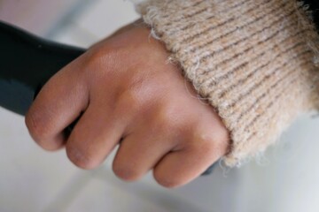Hand von afrikanischem Mädchen umfasst Lenker von Roller in Stadt