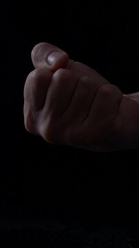 male hand extends the middle finger in a gesture that conveys defiance frustration or discontent. The dark background emphasizes the boldness of the gesture and the emotion behind it.