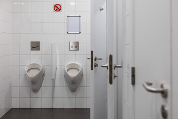 Public bathroom for men with automatic flushing urinals and toilets