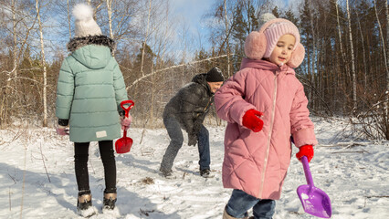 Playful family enjoying snowball fight in snowy winter park