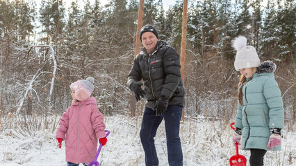 Playful family enjoying snowball fight in snowy winter park