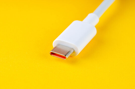 White USB Type-C cable on bright yellow background, macro close-up