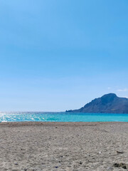 Obraz premium Sunny Day at the Beach with Mountain and Clear Blue Sky