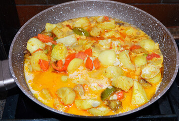 cooking vegetable, dietary stew: zucchini, carrots, bell peppers, eggplants and potatoes. at the end of cooking, chicken egg is added. tasty and healthy food diet