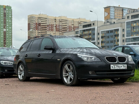 BMW E61 5-series parked in the city street. Exterior Germany black BMW 5 series E61 station wagon parked in the center of the town. Germany premium car. 