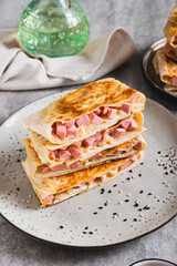 Crispy envelopes with sausage and cheese in flat bread on a plate on the table vertical view