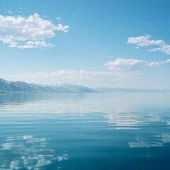 Obraz premium Serene waters reflecting a tranquil blue sky with distant mountains in view