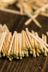 a large number of thin wooden matches with a green sulfur head, side view