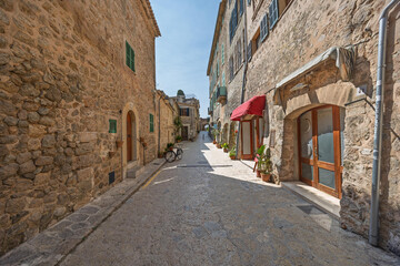 Charming valldemossa cobblestone street invites exploration on sunny day in mallorca