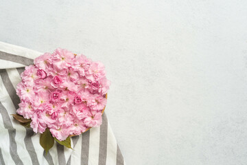 Pink cherry blossom bouquet on striped cloth with light gray background