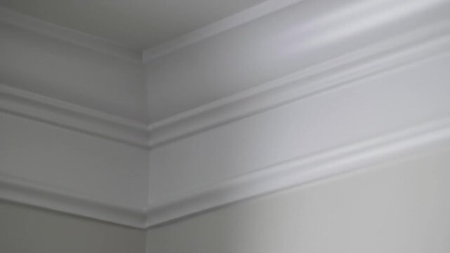 Detailed View Of A Room Corner With Decorative Moulding On The Ceiling