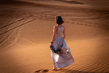 Beautiful girls in a beautiful flowing dress in desert condition