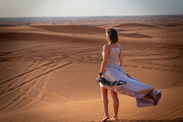 Beautiful girls in a beautiful flowing dress in desert condition