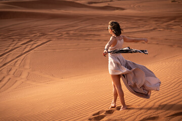 Beautiful girls in a beautiful flowing dress in desert condition
