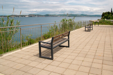 Empty benches on seaside promenade with ocean view – peaceful coastal walkway