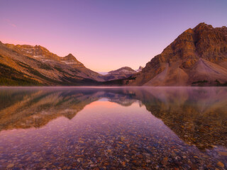 Bow lake, Alberta, Canada. Mountain landscape during sunrise. Reflections on the surface of the water. Sunbeams in a valley. Background, wallpaper, postcards.