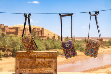 Colorful traditional souvenir bags wallets selling on the market streets of ancient Ait Benhaddou ksar village, Ouarzazate province, Morocco