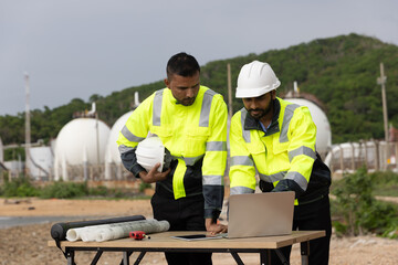 Two Industry engineers stand and discussion work at front factory , Refinery and gas petrochemical plant 
