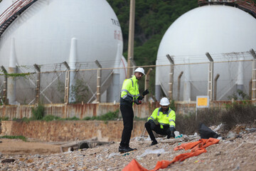 Two safety and environment inspectors  investigate a site, Environment engineer team with green safety jacket and PPE audit environment around factory Industrial and environment