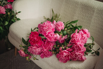 Bouquet of beautiful peonies on a pouf indoors