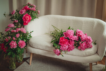 Bouquet of beautiful peonies on a pouf indoors