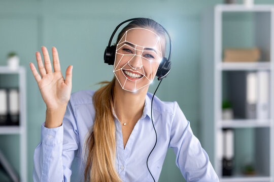 A professional woman smiles at a camera while wearing headphones and engaging with facial recognition technology for identification verification.