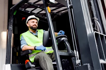 Fotobehang Work in warehouse, loading organic fruits for sale and production of juices. Smiling guy driver in helmet in forklift truck lifts up wooden container full of red ripe apples, on storage background © Prostock-studio
