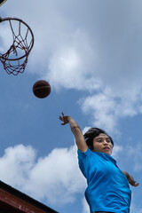 Denpasar, 13 Feb 23: A young athlete performs a slam dunk at a street basketball court under the...