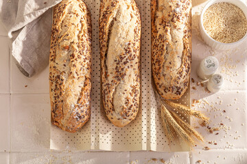 Crispy and hot wholegrain baguettes baking with sesame seeds.