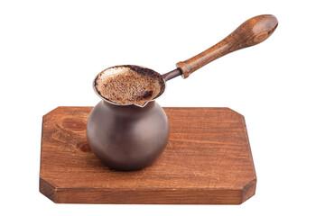 Ready coffee in a Turk on a brown wooden board, isolate.